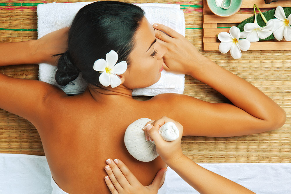 view of young woman in spa environment is being massaged